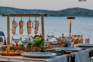 a table with plates of food and wine glasses at Orkide Bodrum in Bodrum City