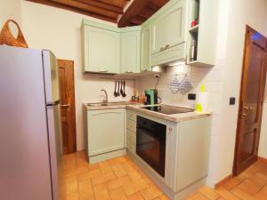 a kitchen with white cabinets and a refrigerator at Le Torri 3 San Gimignano in San Gimignano