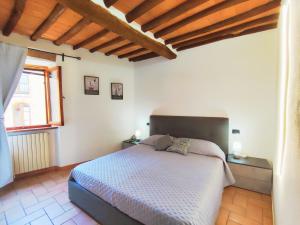 a bedroom with a bed and a large window at Le Torri 3 San Gimignano in San Gimignano