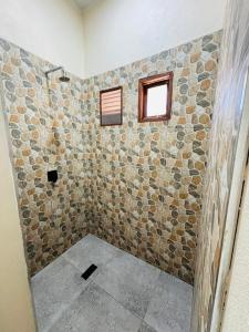 a bathroom with a stone wall at Casa Regina in Vilanculos +36 photos