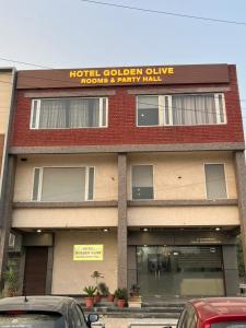 a hotel cyber club with cars parked in front of it at Hotel Golden Olive in Kurukshetra
