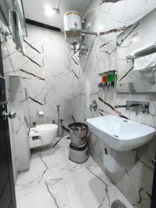 a white bathroom with a sink and a toilet at Hotel Golden Olive in Kurukshetra +21 photos