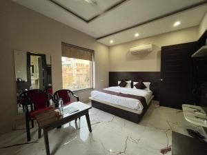 a bedroom with a bed and a table and chairs at Hotel Golden Olive in Kurukshetra
