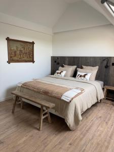 a bedroom with a large bed and a bench at B&B Bodegem in Dilbeek