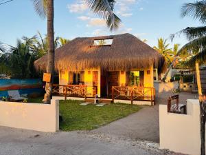 a small hut with a thatched roof on a beach at Casa Regina in Vilanculos