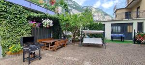 a patio with a bench and a table and chairs at Apartments Giovannini in Fai della Paganella