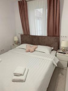 a bedroom with a bed with towels on it at Lad Petite Maison in Craiova +41 photos