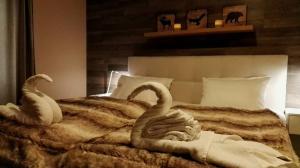 two towel swans are sitting on a bed at Kvitfjell Hotel Kvitfjellvegen 492 in Kvitfjell