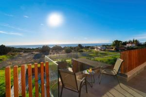 a patio with two chairs and a table on a balcony at Aethrion Villas & Suites in Gennadi