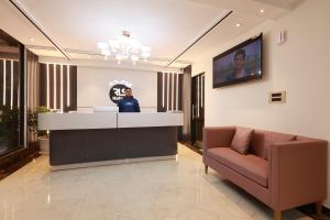 a lobby with a reception desk and a couch at RLS Hotels, Greater Noida Near Expo Centre & Mart in Greater Noida