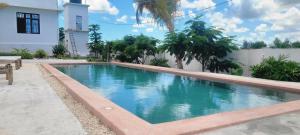 a swimming pool in front of a house at Villa Katerina-Zanzibar Apartment Paje in Paje