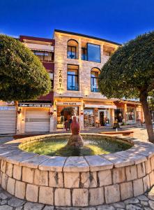 a large fountain in front of a building at Z art Hotel in Krujë