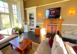a living room with a couch and a fireplace at Edinburgh Country Estate Rooms & Apartments in Gorebridge