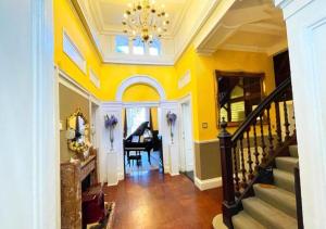 a hallway with a staircase and a grand piano at Edinburgh Country Estate Rooms & Apartments in Gorebridge