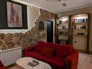 a living room with a red couch and a stone wall at Casa Axier - Piscina Privada - Aire Acondicionado - Barbacoa in Biar