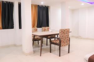 a table and chairs in a room with curtains at Kanha Gold in Bhopal +65 photos
