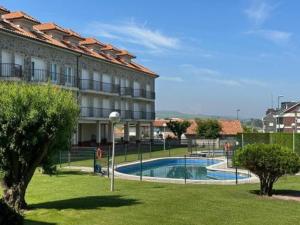 a building with a swimming pool in front of a building at Suances Costa Quebrada in Suances +11 photos