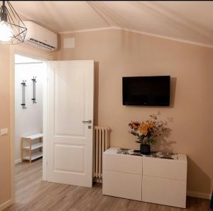 a living room with a tv on the wall and a white door at Il limone in Gargnano