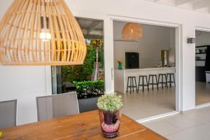 a dining room and kitchen with a table with a vase at Tropical villa Curoyal near the beach in Jan Thiel