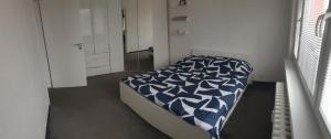 a bedroom with a bed with a blue and white comforter at Apartman Naty in Banská Bystrica