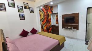 a bedroom with a bed and a tv on the wall at Shree Nagnath Residency in Ellora