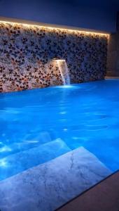 a swimming pool with a waterfall in a building at Favorite Room&Spa in San Giuseppe Vesuviano