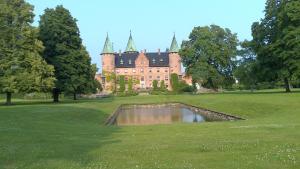 a castle with a pond in front of it at B&B Ströprodukter in Eslöv