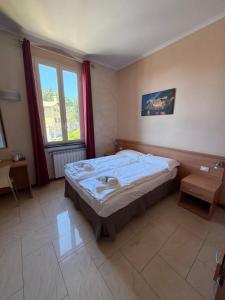 a bedroom with a bed and a large window at Hotel Villa Flora in Bogliasco