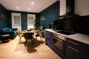 a kitchen with a table and a dining room at L'Atelier de l'Émeraude in Saverne +8 photos