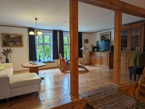a living room with a couch and a tv at Landhaus Oldorf in Rodenäs