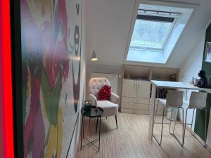 a living room with a chair and a table at SLEEP INN Bed&Breakfast in Amblève