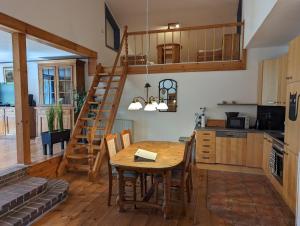 a kitchen and dining room with a wooden table and stairs at Landhaus Oldorf in Rodenäs