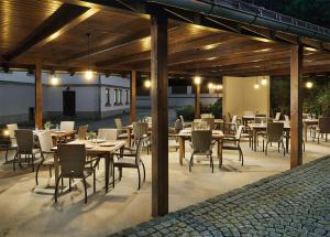 a restaurant with wooden tables and chairs and lights at Penzion Čítkův Mlýn in Šluknov