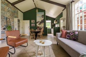 a living room with a couch and a table at Bungalow de Mees in Schoonloo