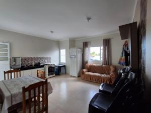 a kitchen and living room with a couch and a table at Chácara Recanto JJ in Sorocaba