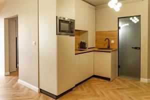 a kitchen with a refrigerator and a microwave at Distinct Ultracentral Apartment in Bistriţa