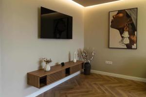 a living room with a television on a wall at Distinct Ultracentral Apartment in Bistriţa +2 photos