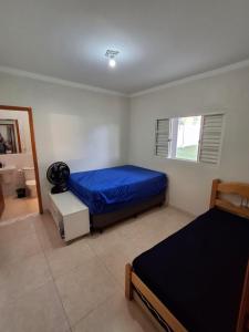 a bedroom with a blue bed and a window at Chácara Recanto JJ in Sorocaba +11 photos