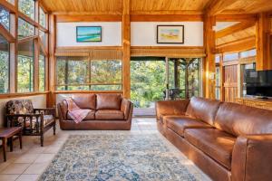 a living room with leather couches and a television at Yallingup Surfing wineries and restaurants in Yallingup