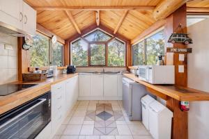 a kitchen with white cabinets and a wooden ceiling at Yallingup Surfing wineries and restaurants in Yallingup
