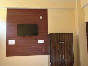 a room with a tv and a wooden wall at Divine homestay in Kukri Ser +9 photos