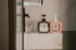 a bathroom with two soap bottles on a counter at DeHa Homestay in Kon Rung (1)
