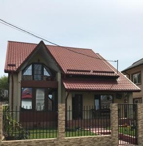 a house with a fence and a red roof at Vila Lidia in Eforie Nord