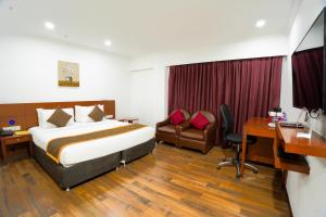 a hotel room with a bed and a desk at The Royal Comfort in Bangalore +78 photos