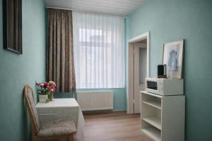 a living room with a table and a microwave at Hotel Elisenhof in Chemnitz