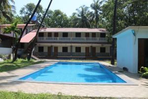 an empty swimming pool in front of a building at Awas Beach Stays in Avas