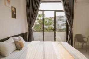 a bedroom with a bed and a large window at DeHa Homestay in Kon Rung (1)