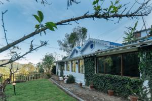 a house with ivy on the side of it at Hideaway Art Residency in Ooty
