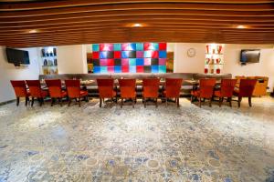 a group of chairs and a bar in a room at The Royal Comfort in Bangalore