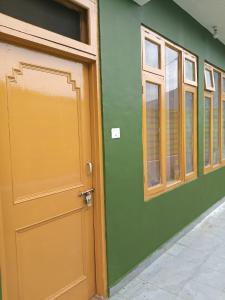 a wooden door on a green building with windows at Divine homestay in Kukri Ser